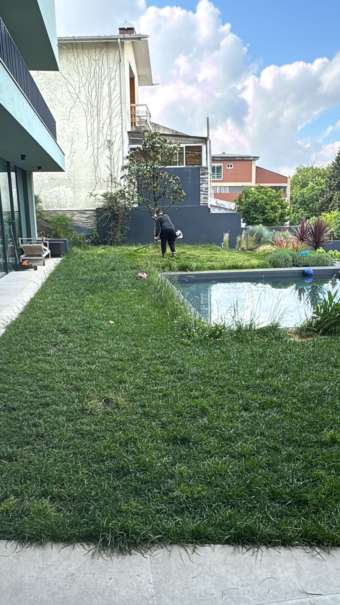 Jardim cuidado com relva cortada e piscina